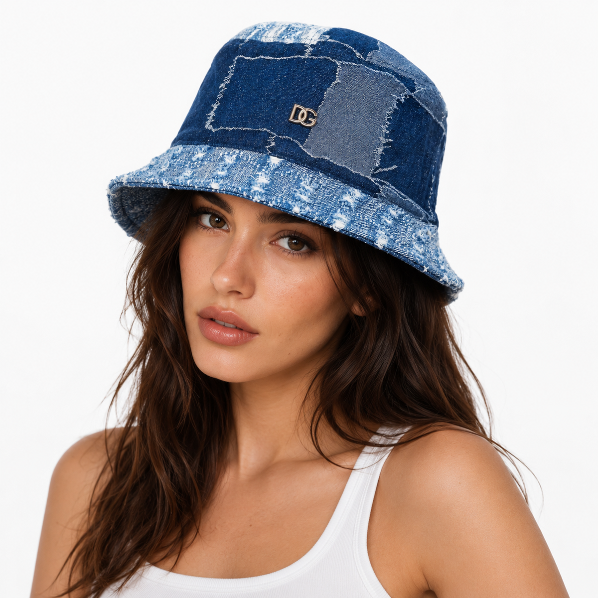 Woman wearing a custom patchwork denim bucket hat with metal logo on a white studio background