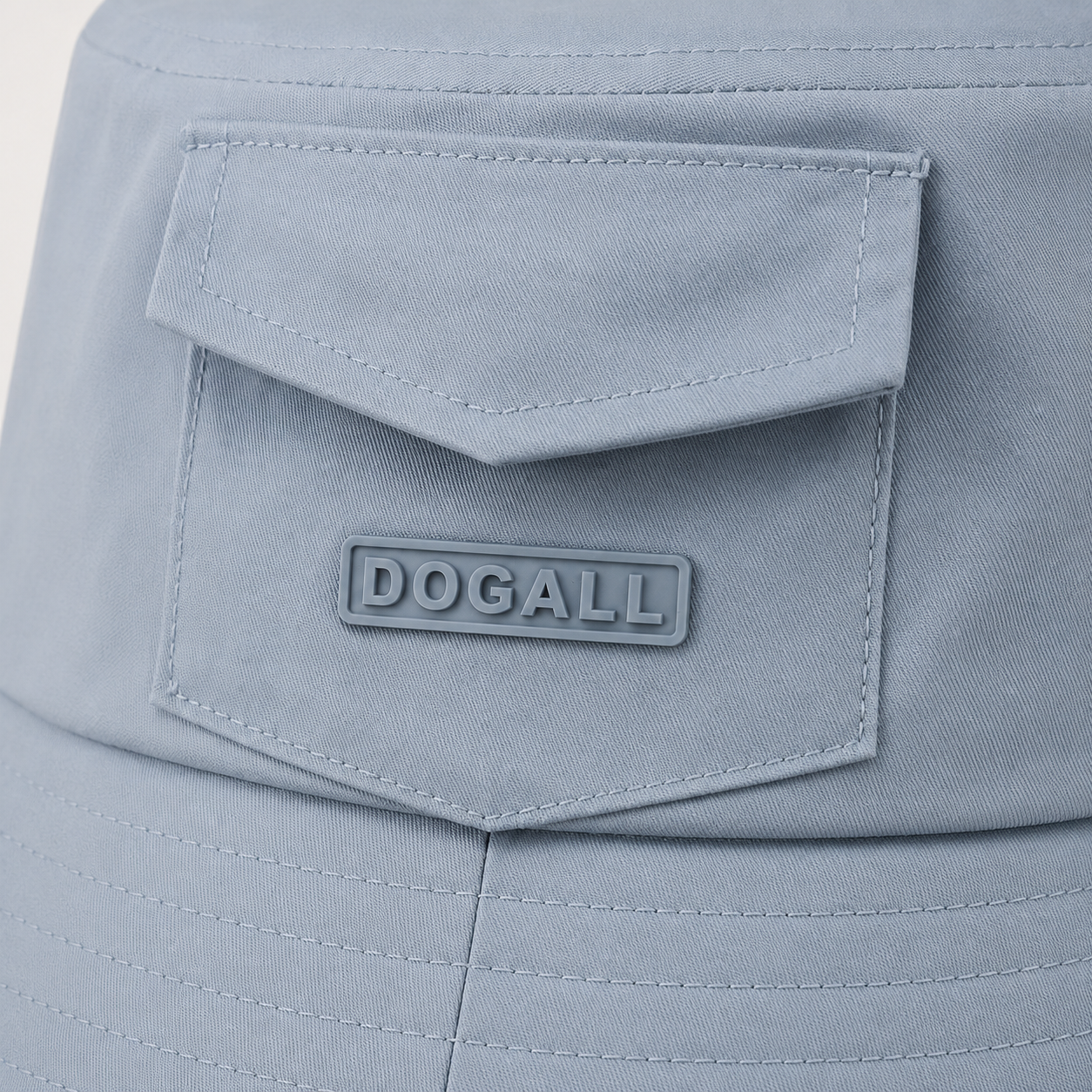 Close-up of custom 3D printed logo on the front pocket of a light blue polyester bucket hat
