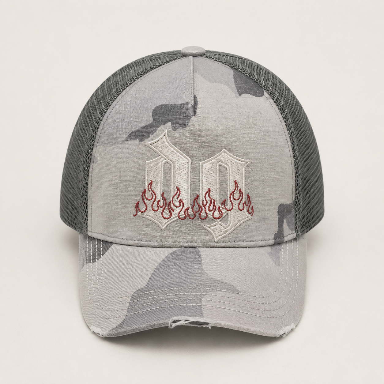 Front view of a custom camo trucker hat with 5 panel cotton front, embroidered logo, curved brim, and mesh back design.