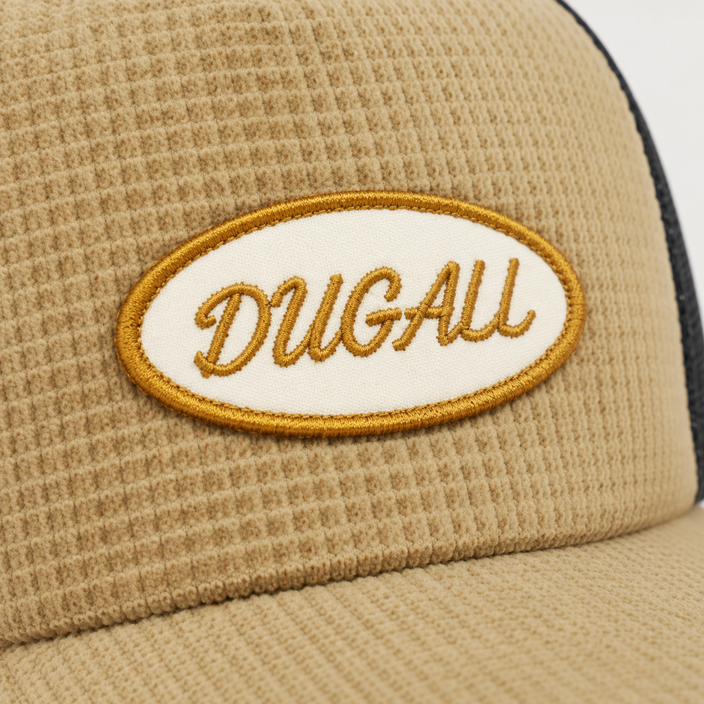 Close-up detail of a custom embroidered logo patch on a textured cotton trucker hat, showing clean stitching, premium embroidery texture, and strong brand customization quality.