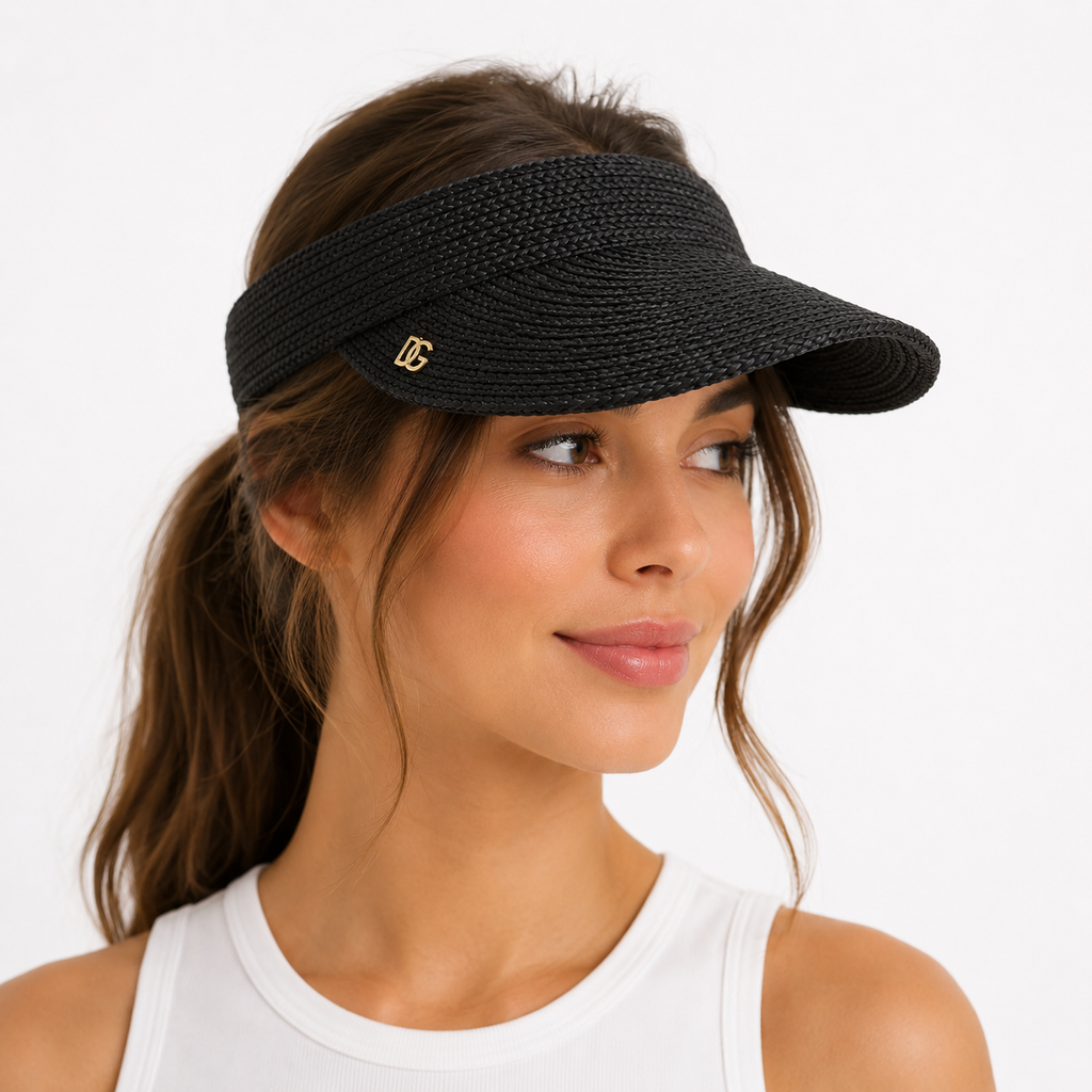 Female model wearing black luxury raffia sun visor with custom metal logo for resort, beach, and outdoor lifestyle.
