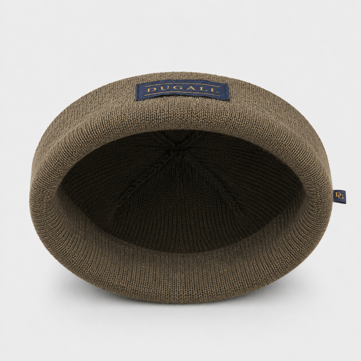 Inside view of an olive brown acrylic knit beanie showing folded cuff, patch label, and knit construction.