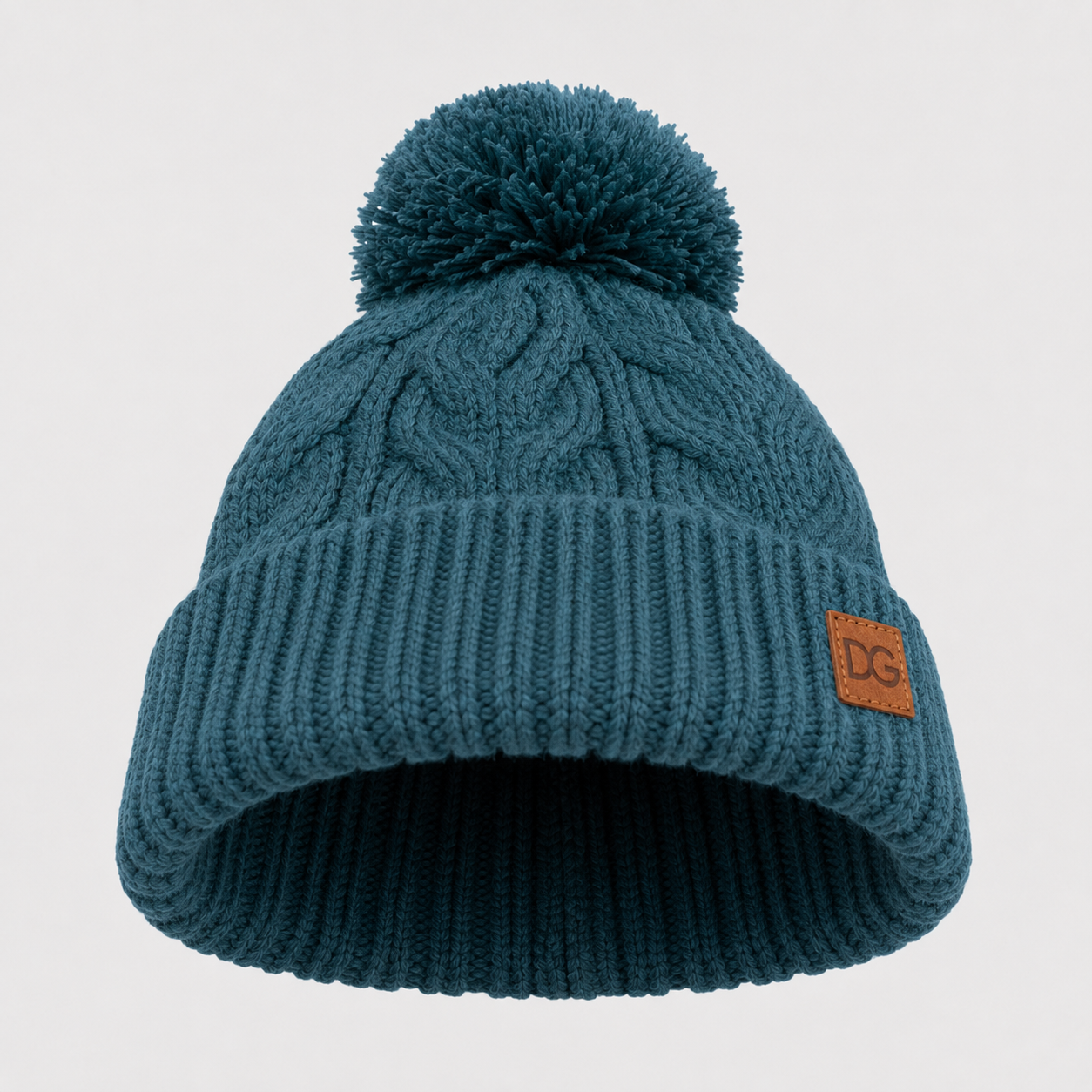 Bottom view of a teal pom pom winter beanie showing the cuffed opening, knit structure, and leather patch placement.