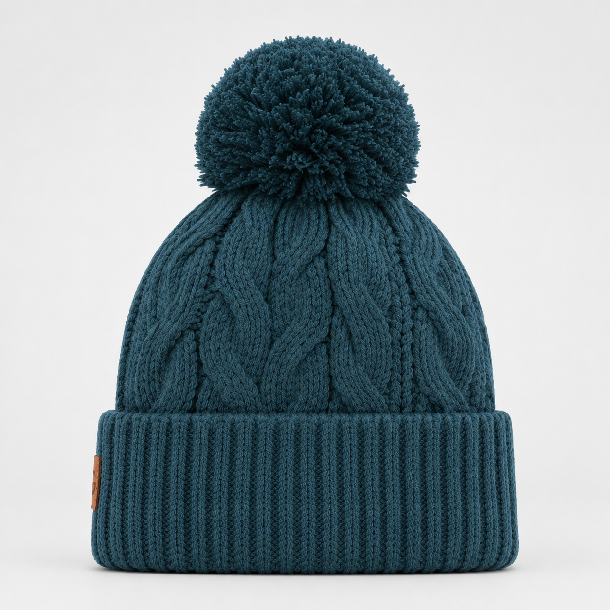 Back view of a teal cable knit pom pom beanie showing the longer fit and ribbed folded cuff.