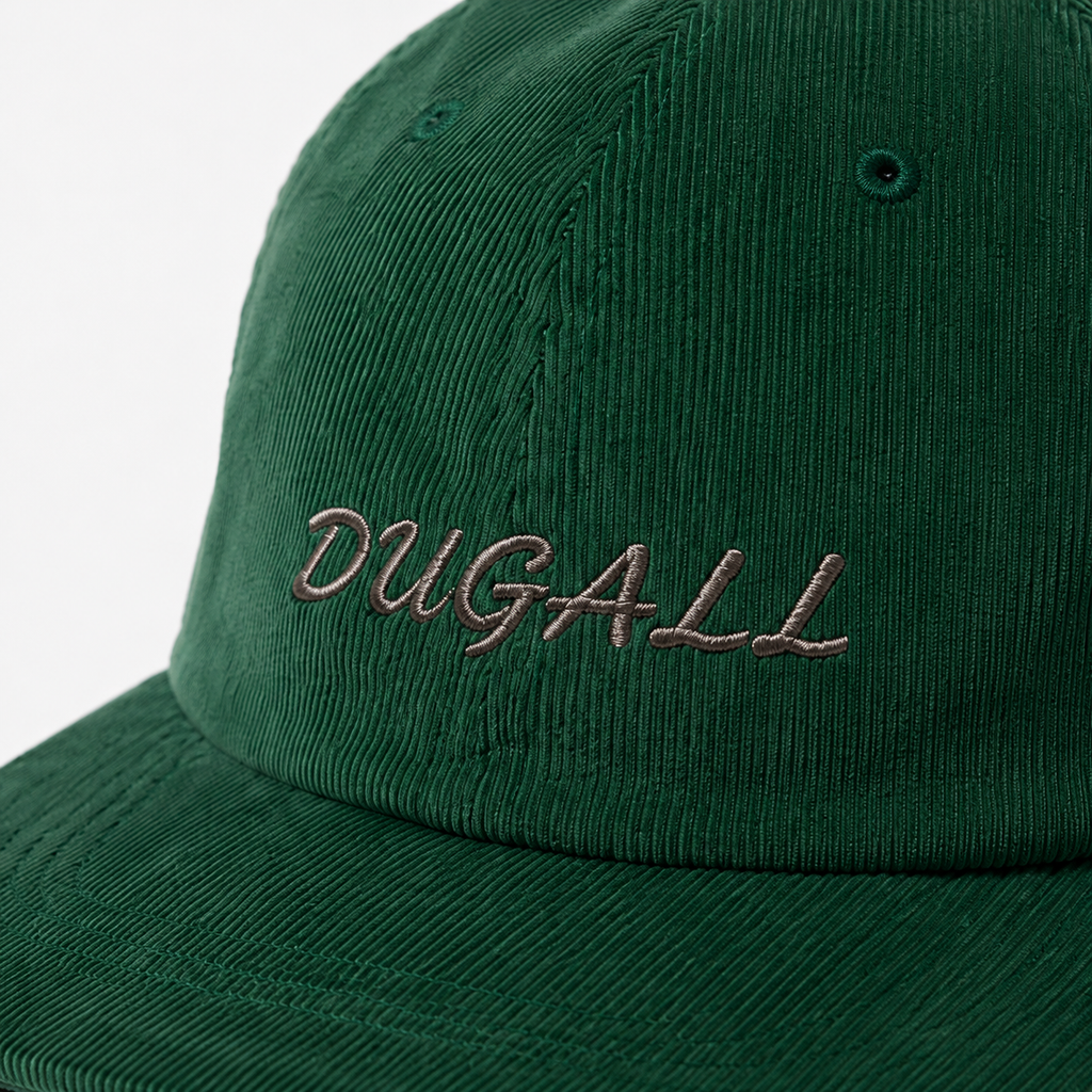 Close-up of custom embroidered script logo on green corduroy fabric baseball cap.