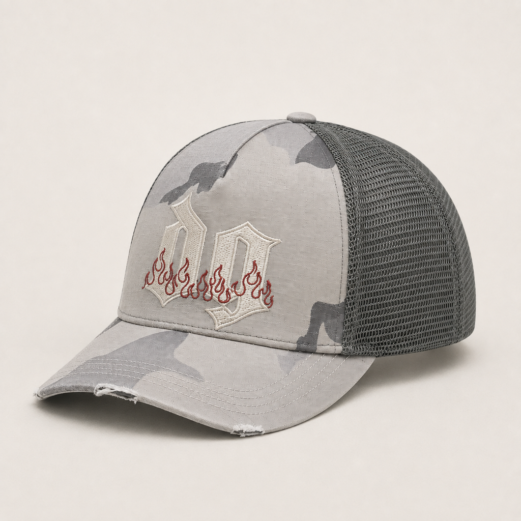Side view of a grey camo custom trucker hat with embroidered logo, cotton front panel, mesh back, and distressed curved brim.