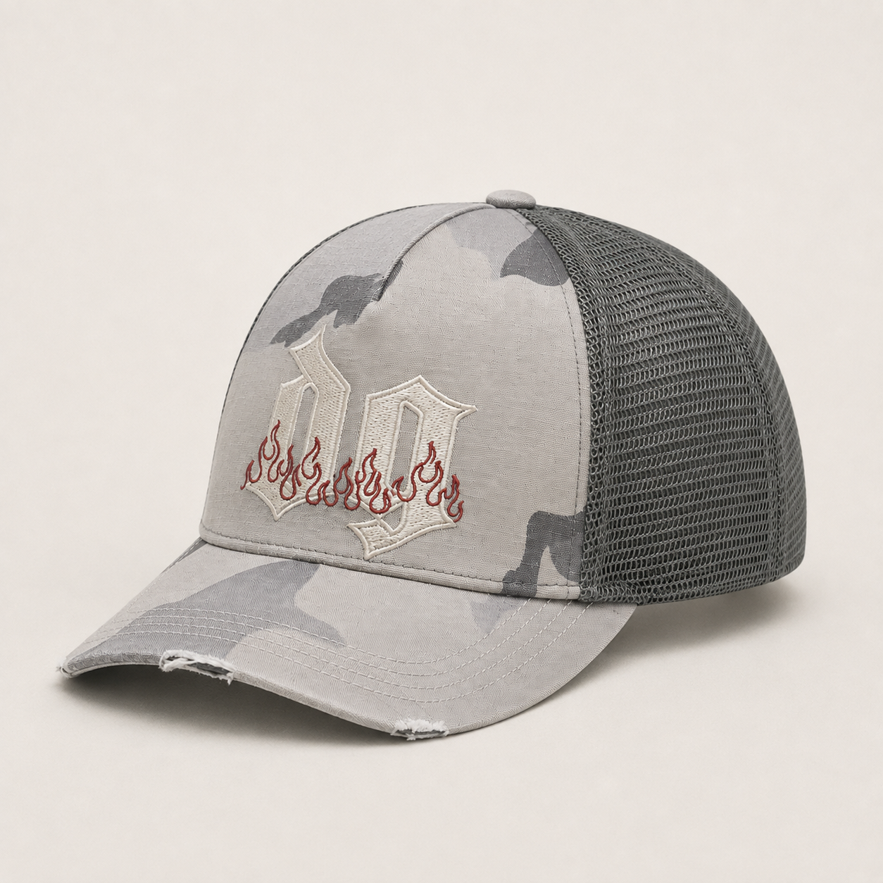 Side view of a grey camo custom trucker hat with embroidered logo, cotton front panel, mesh back, and distressed curved brim.