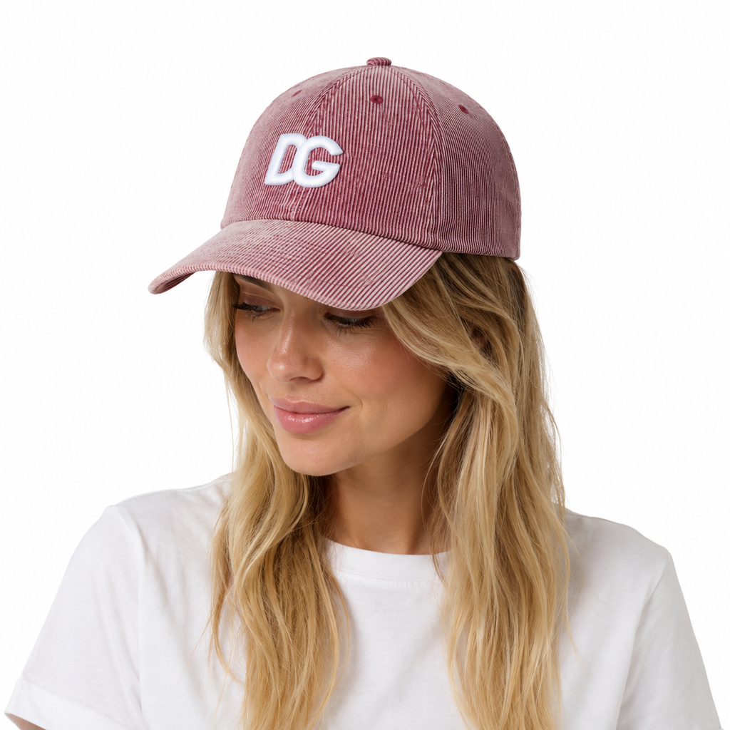 Female model wearing a pink washed corduroy snapback-style baseball cap with raised embroidered DG logo.