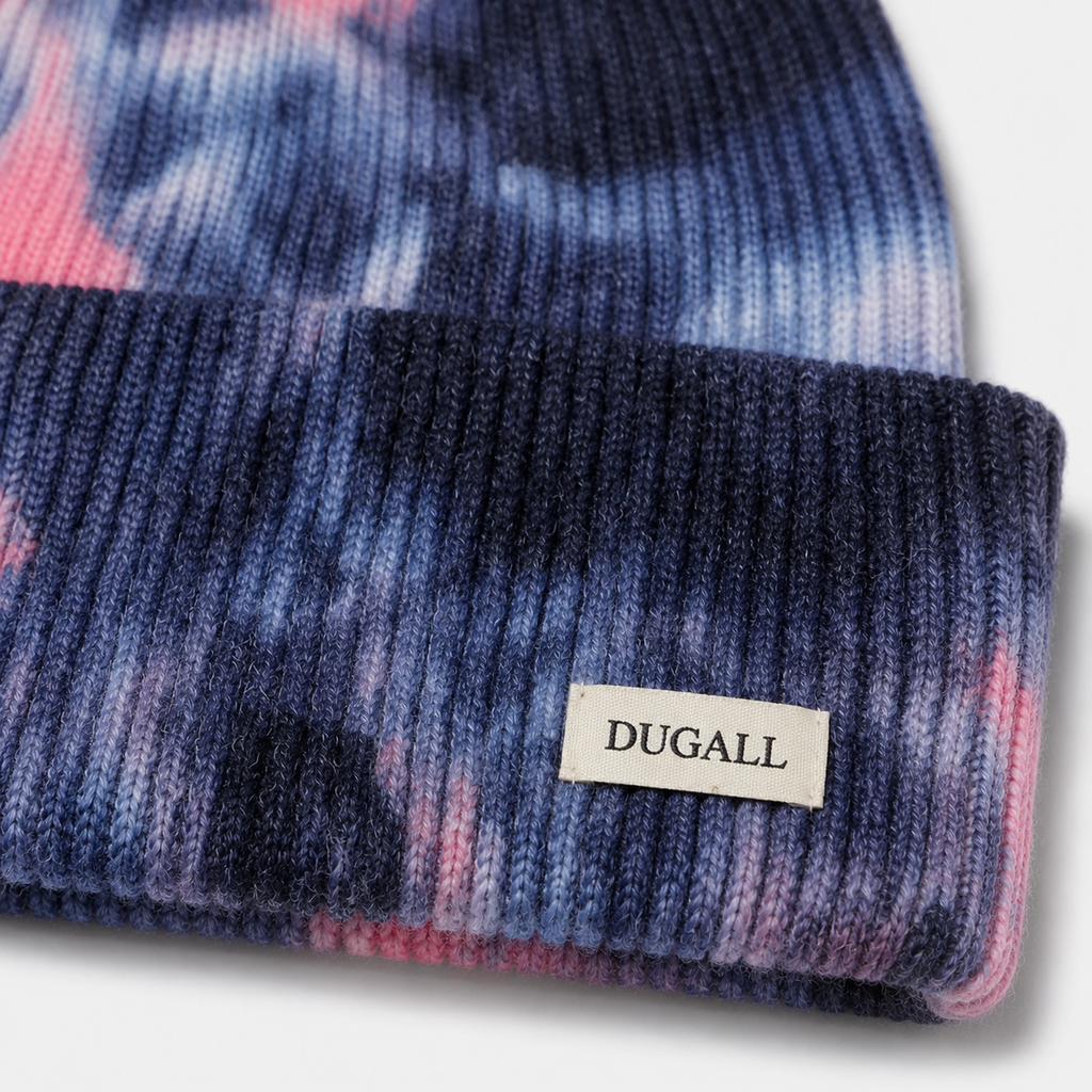 Close-up of custom DUGALL logo label on a colorful tie dye acrylic knit beanie.