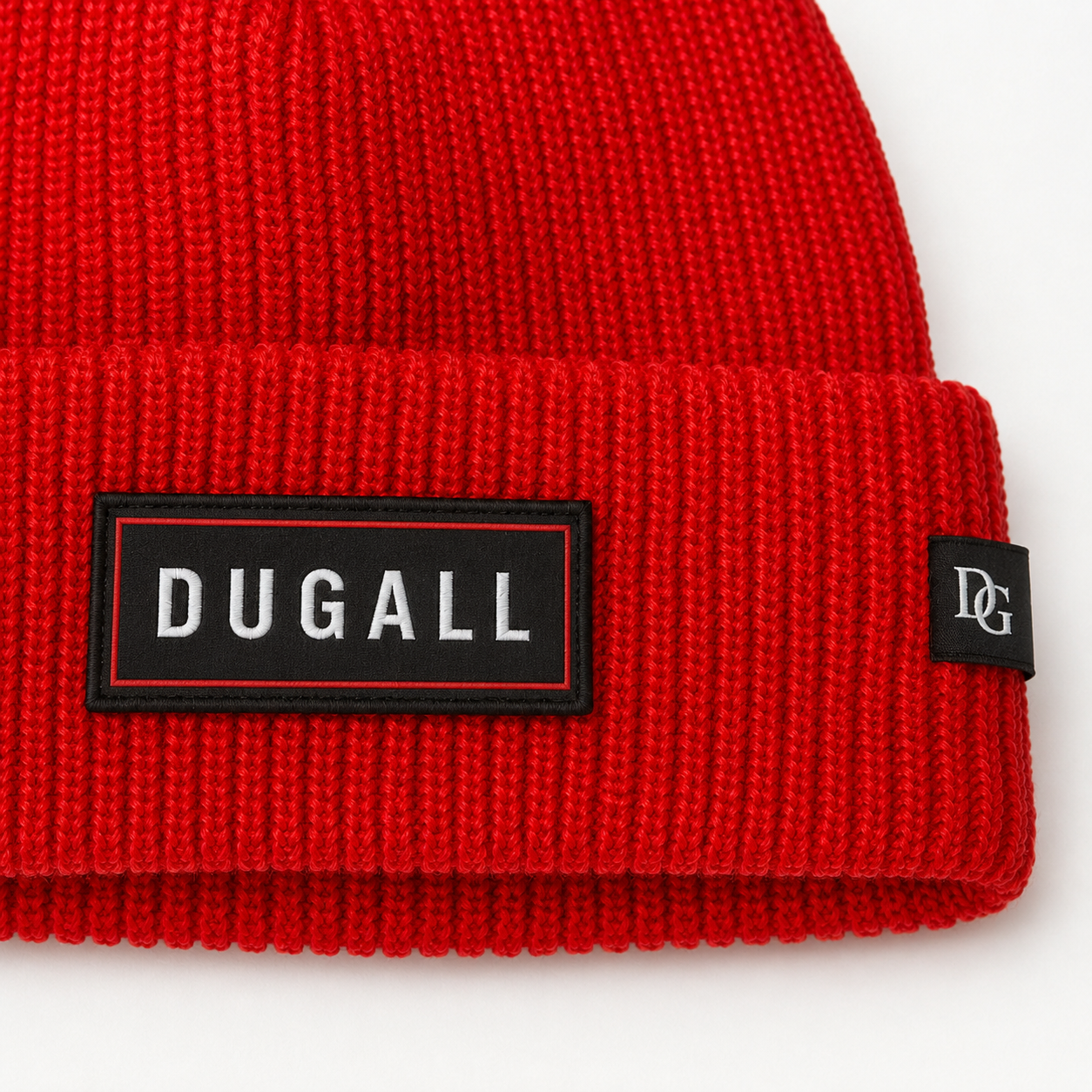 Close-up of custom embroidered patch logo and side label on a red ribbed knit beanie.