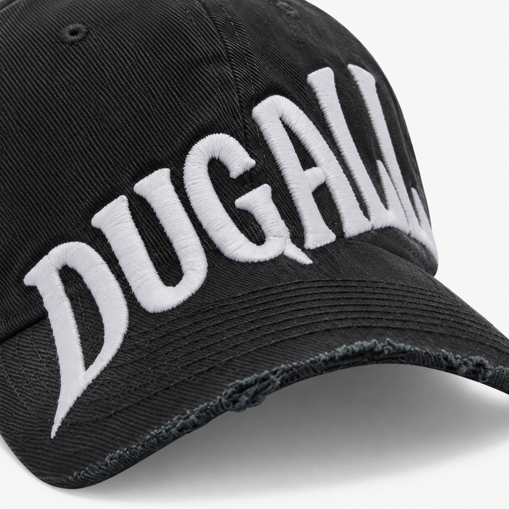 Close-up of large white embroidery logo on black cotton snapback hat with distressed brim detail.