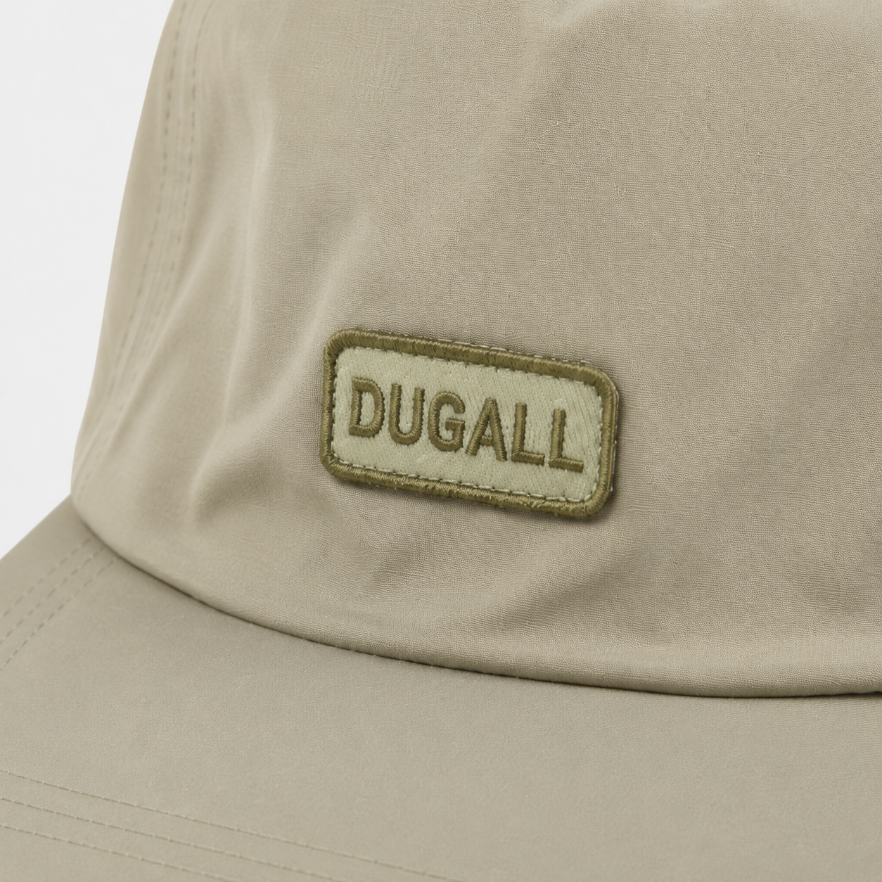 Close-up of embroidered DUGALL logo patch on khaki custom baseball cap with clean 5 panel front