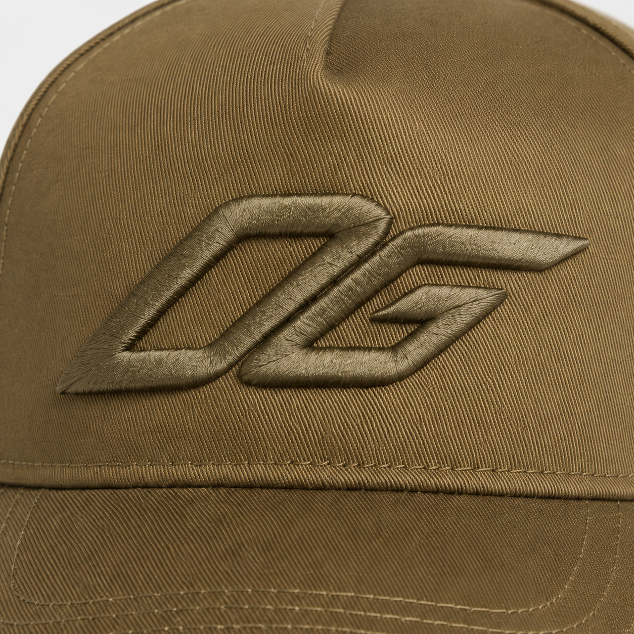 Close-up of raised 3D embroidery logo on an olive custom snapback hat