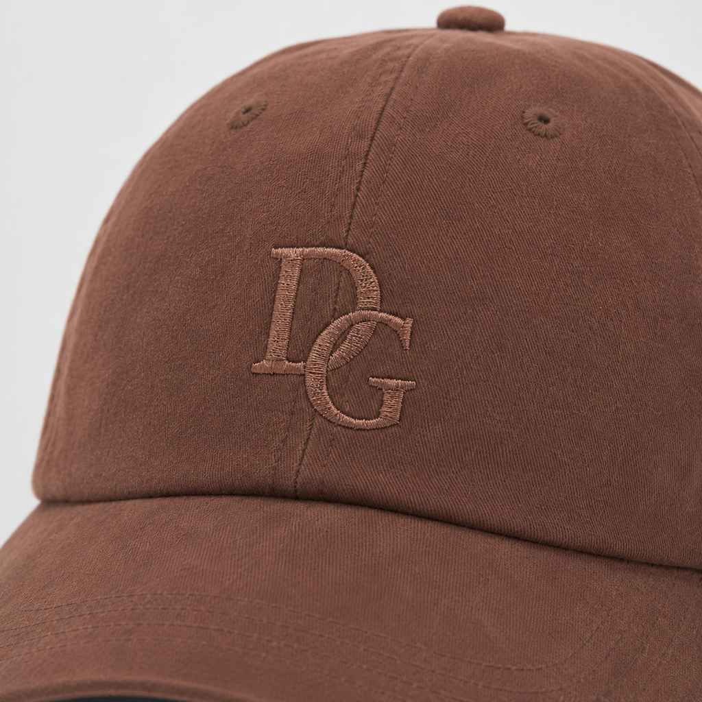 Close-up of tone-on-tone embroidered DG logo on a coffee brown washed cotton dad hat.