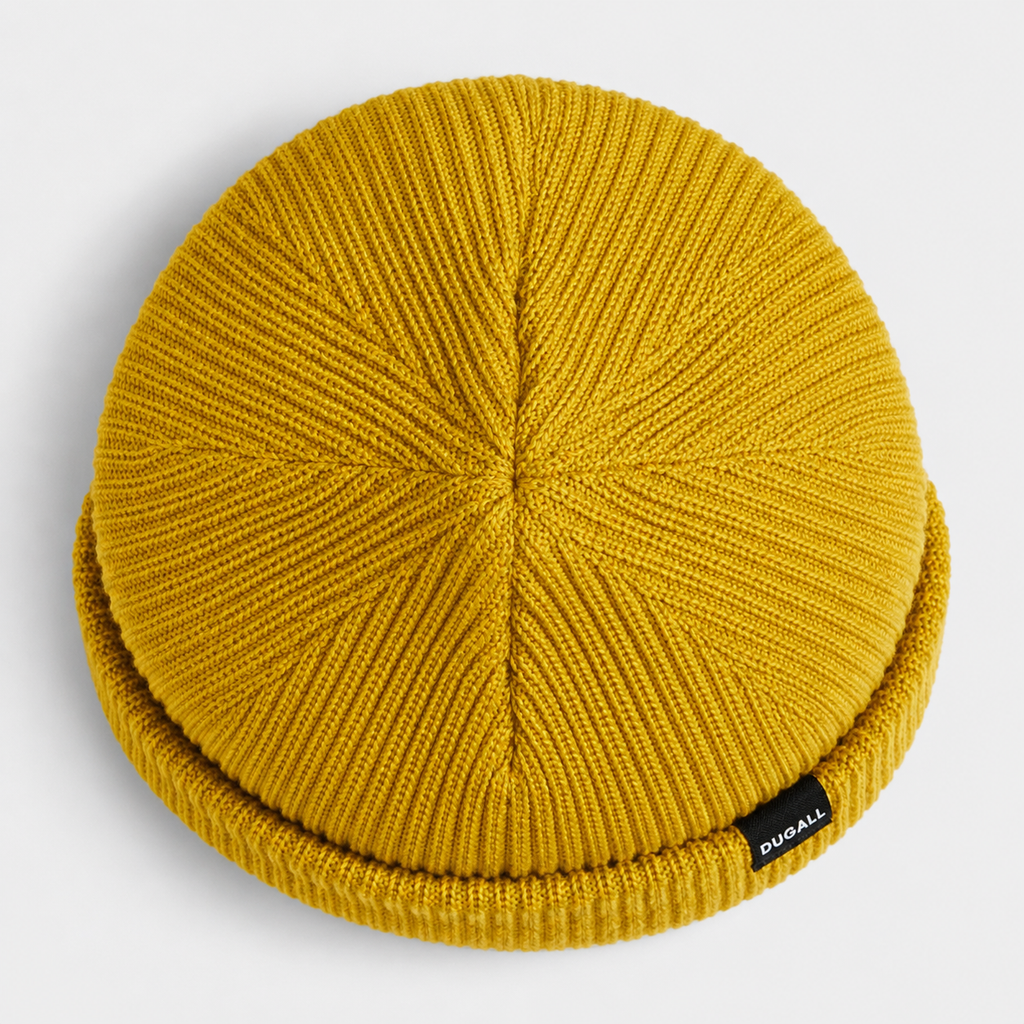 Top view of a mustard yellow acrylic ribbed beanie showing knit construction and folded cuff detail.