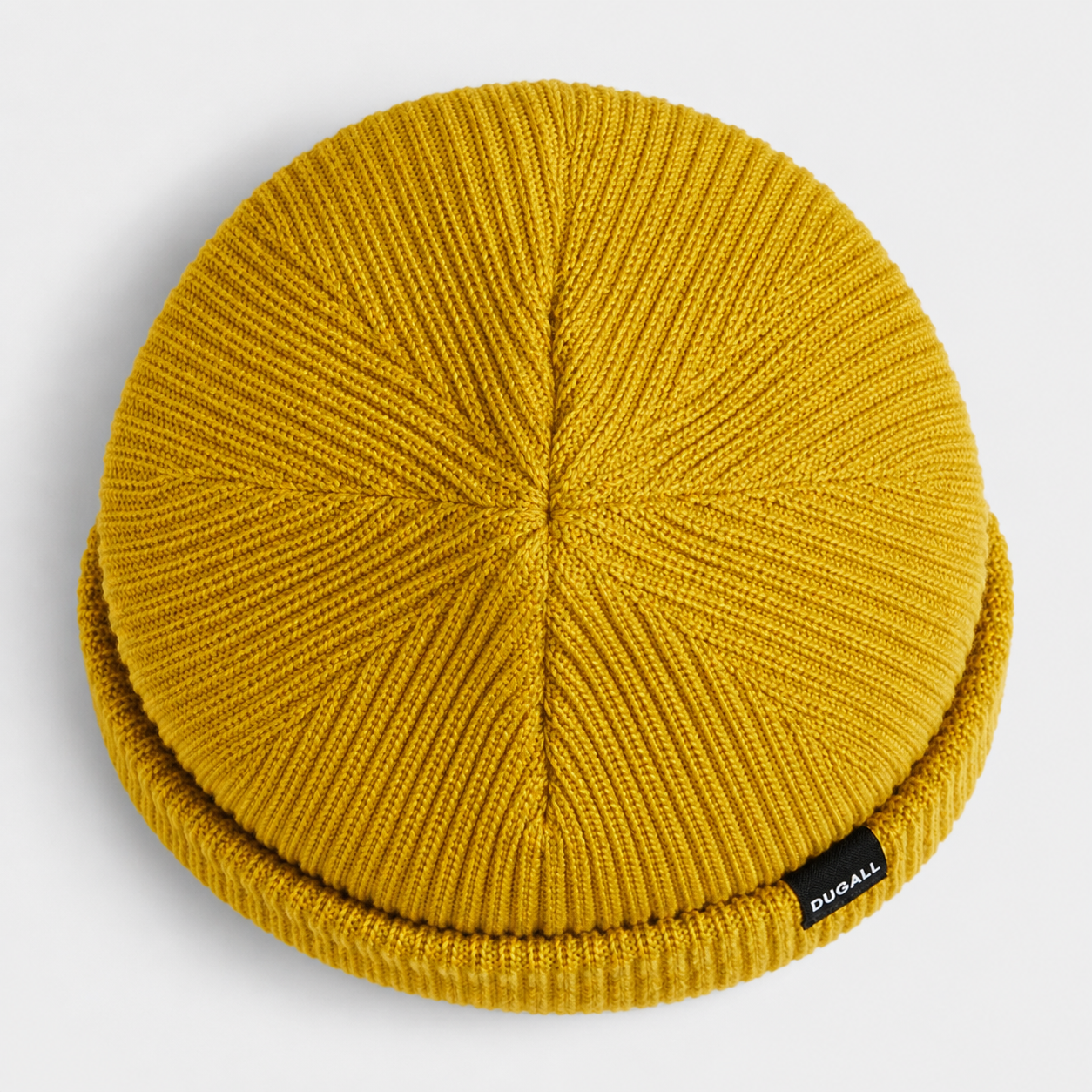 Top view of a mustard yellow acrylic ribbed beanie showing knit construction and folded cuff detail.