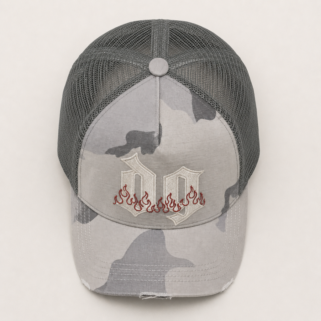 Top view of a custom 5 panel camo trucker hat showing cotton front panel, breathable mesh back, and embroidered logo detail.