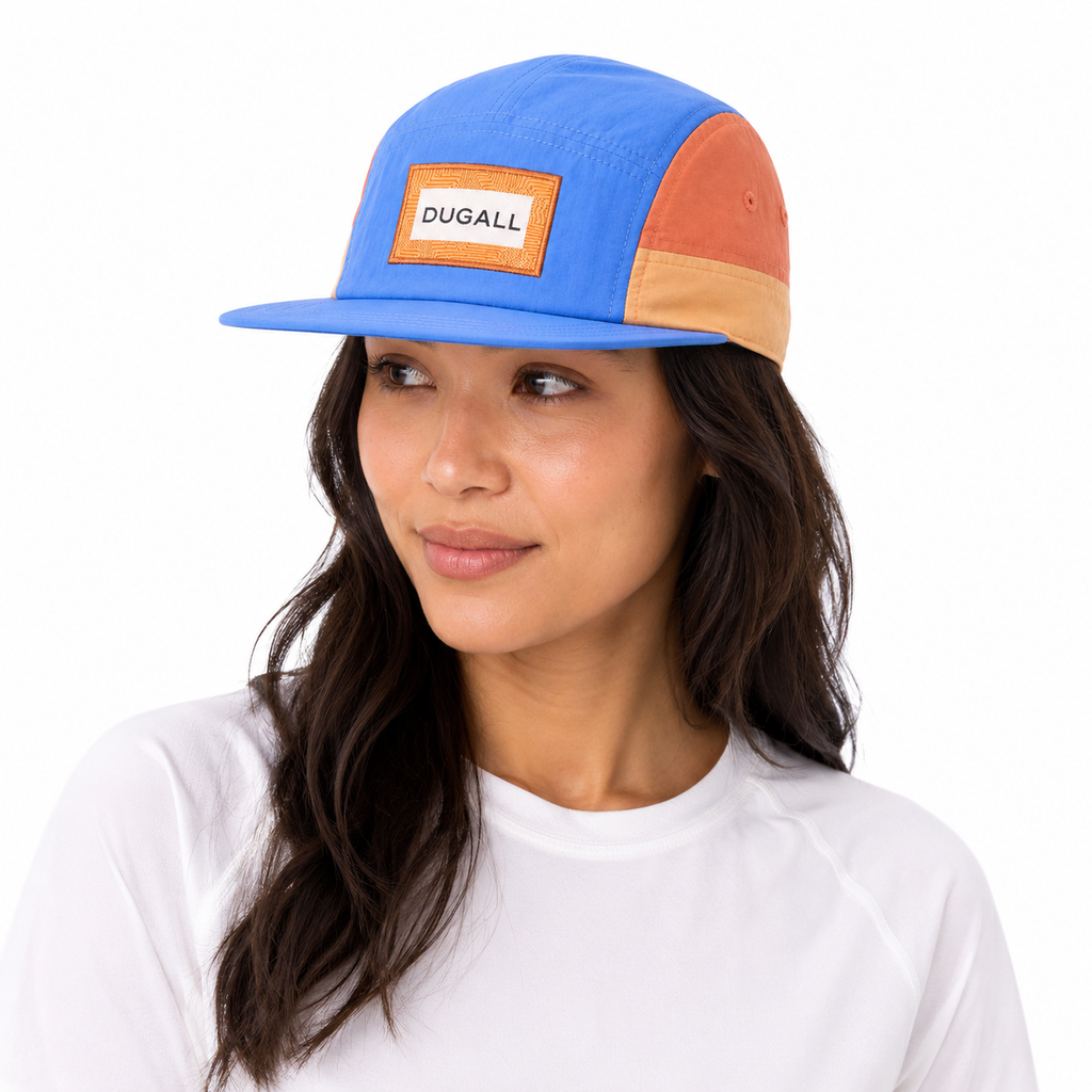 Female model wearing a custom color block nylon 5 panel baseball cap with patch label logo and flat brim.