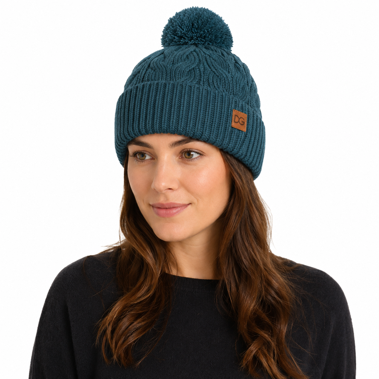 Female model wearing a teal pom pom beanie with cable knit texture and custom leather patch logo.