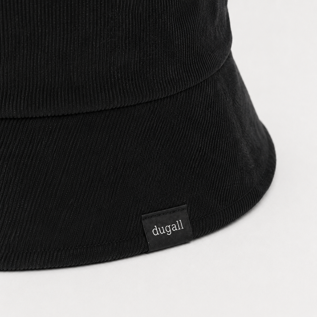 Close-up of custom woven side label logo on black cotton bucket hat with ribbed texture